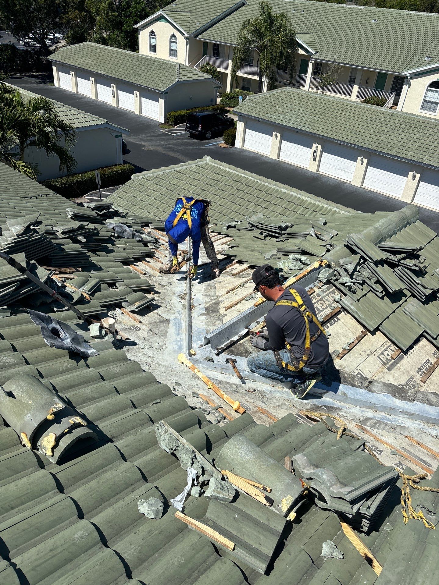 Crew replacing concrete barrel tile on occupied units